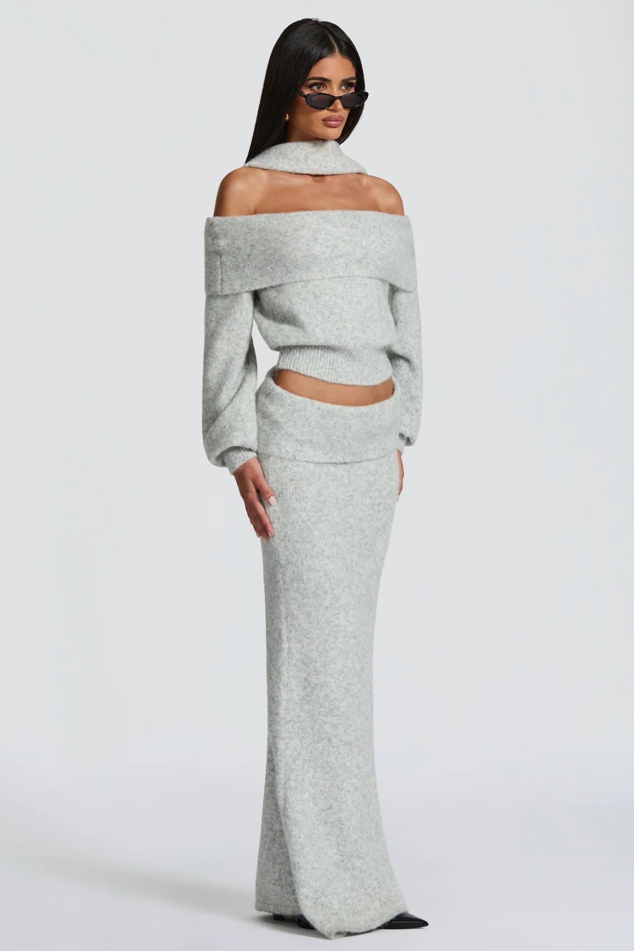 Set BIANCA composto da maglia off-shoulder e gonna lunga a sirena. Realizzato in morbida maglia calda, avvolge la silhouette con eleganza e comfort. Il design con collo ad anello e spalle scoperte aggiunge un tocco sofisticato e sensuale
